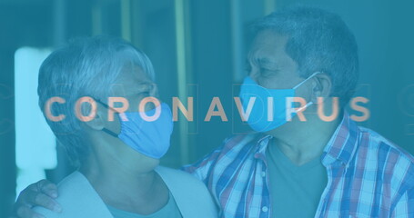 Image of covid 19 text over senior couple embracing wearing face masks
