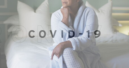 Image of covid 19 text over sad senior woman