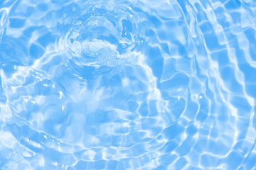 Water surface. Bluewater waves on the surface ripples blurred. Defocus blurred transparent blue colored clear calm water surface texture with splash and bubbles. Water waves with shining pattern.