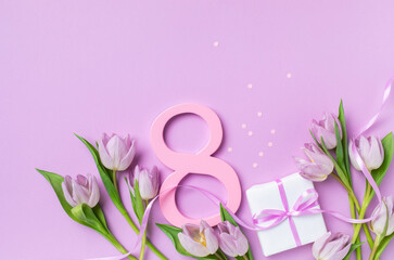 8 March. International Womens Day greeting card. Gift box and heap of fresh beautiful tulip flowers on pastel lilac table top view.