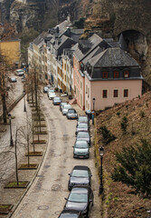 The view of a line of cars and colorful houses on the slope in historic area of Luxembourg