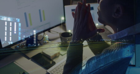 Image of biracial businessman using computer over data processing and cityscape