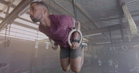 Image of interface processing data over biracial man training on gym rings at gym