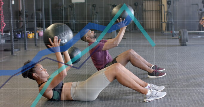 Image of graph processing over diverse man and woman cross training with medicine balls at gym - Powered by Adobe