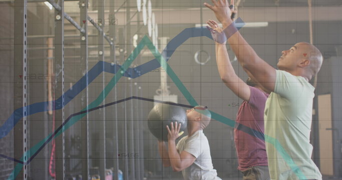 Image of graph processing data over diverse male group cross training with medicine balls at gym