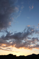 cloud and vanilla sky background with dark mountain silhouette