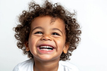 Smiling child with curly hair enjoys playful moment. Childhood joy and expressions.