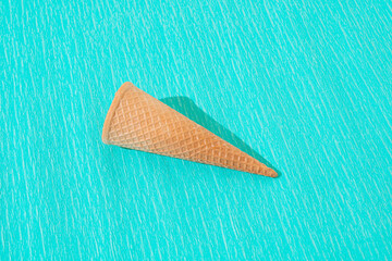 Ice cream cone on turquoise blue background. Minimal summer sweet food concept.