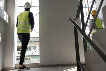 Caucasian engineer man and woman working with paper work at construction site	