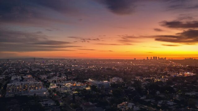 Aerial hyperlapse view of beautiful orange sunset sky over city of Los Angels cityscape. 