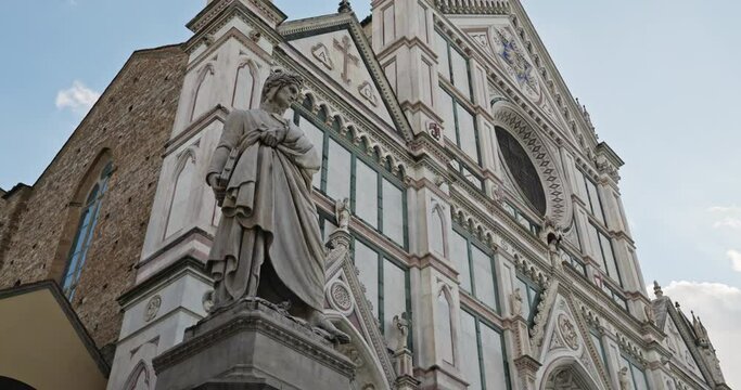 Statue of Dante Alighieri near the Basilica of Santa Croce, Florence, Italy. Beautiful architecture of the facade of the cathedral in the historical center of the tourist city. High quality 4k footage