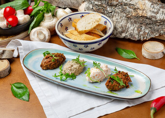 Assorted pates in a plate on a wooden background
