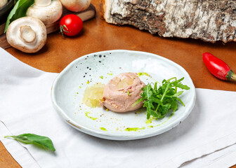 Chicken pate with pear and arugula in a plate on a wooden background