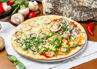 Italian pizza four seasons with pear, mushrooms, shrimp, roast beef and arugula on wooden background
