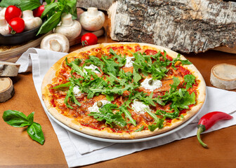 Italian pizza with salmon and arugula on wooden background