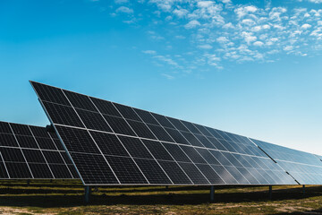Naklejka premium row of solar panels under blue sky, in new solar photovoltaic plant, bright sunny day