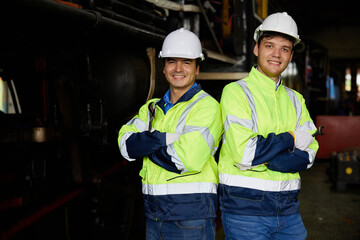 portrait engineers or workers smiling and crossed arms pose at a train construction site