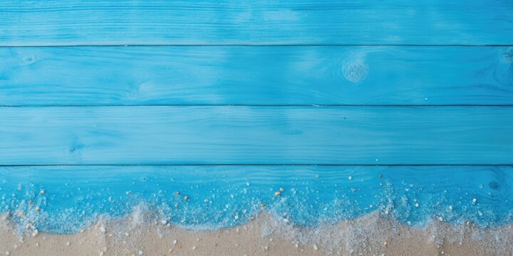 Top view of blue wooden floor with copy space, covered in sea sand.