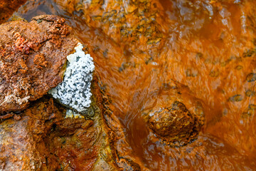 Contrast of Crystal Deposits on Iron-Rich Rocks in Rio Tinto