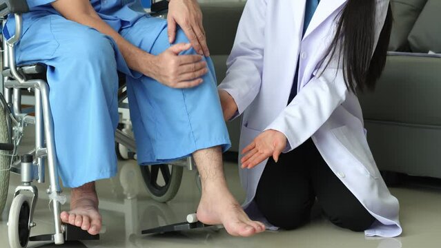 A caring female doctor provides medical care to a male patient in a wheelchair who has knee and ankle pain due to overwork. Shock received medical attention from doctors at the hospital.