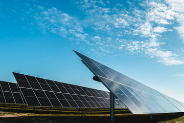 side of row of solar panels in photovoltaic solar plant, bright sunny day