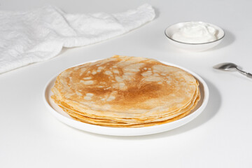 Thin pancakes in a plate. Concept of delicious breakfast or Maslenitsa