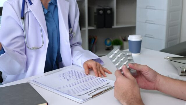 The doctor or pharmacist advises patients about pills. The doctor prescribes medication sitting at a table in the clinic office. to find the best course of treatment. follow-up treatment.