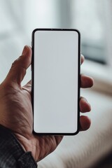 Mockup image of a hand holding black smartphone with blank white screen