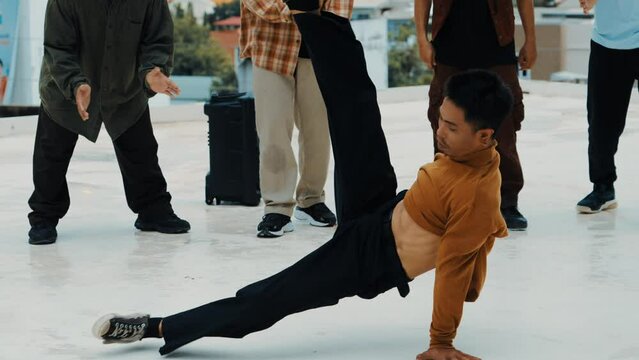 Professional hispanic break dancer practice B boy dance while multicultural friends at roof top. Young modern dancing group doing hip hop movement. Style,fashion,action. Outdoor sport 2024. hiphop.