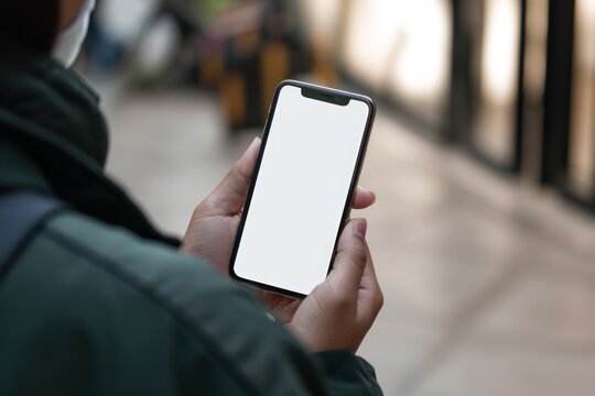 Mockup image of a woman holding smart phone with blank white screen on blurred background