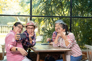 Group elderly mature business owner friends meeting in eatery restaurant using phone selfie take photo together, senior pension female happy free time celebation holiday, wellness aging care lifestyle