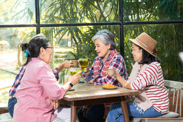 Group of elderly Asian friends enjoy Tea time in cafe with cake, talking, luaghing enjoy free time holiday after retirement, senior pension females spend time together in coffee shop meeting lifestyle