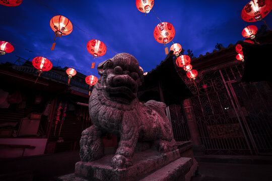 The Chinese Goddess of Mercy temple lion statue illuminated by lanterns, Georgetown, Malaysia