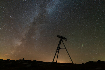 telescope on a tripod against the background of the starry sky
