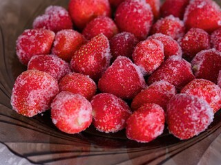 A plate with a frozen strawberries on it.