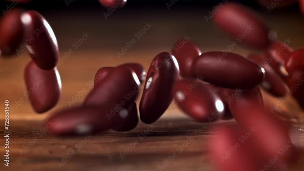 Sticker Red beans falling on a wooden table. Filmed on a high-speed camera at 1000 fps. High quality FullHD footage