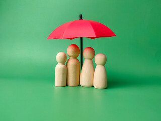 A wooden peg doll family cover by red umbrella © Mohd Azrin