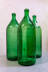 Three green glass wine bottles on a white background