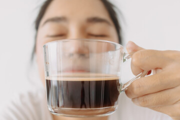 Close up of woman holding and showing hot coffee mug, smelling aroma sense tea cup in the morning, isolated over white background wall.
