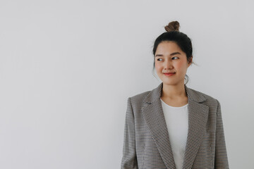 Asian Thai woman smiling and looking at empty space side, businesswoman wearing blazer suit and bun...
