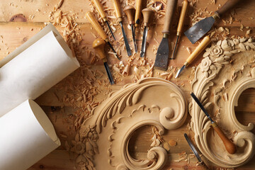 Workshop setting, professional wood carving tools surrounding floral pattern in progress. Wood...