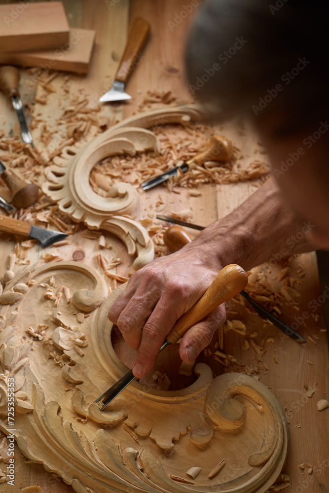 Wall mural timber, wood processing. joinery work. wood carving with work tools close up. hand of carver carving