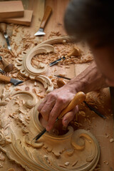 Timber, wood processing. Joinery work. Wood carving with work tools close up. Hand of carver carving wood. Craftsman carving with a gouge