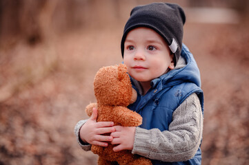 Toddler with Teddy Bear in Nature. Innocent toddler clutching a teddy bear, a comforting presence on his outdoor adventure