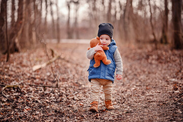 Toddler with Teddy Bear in Nature. Innocent toddler clutching a teddy bear, a comforting presence on his outdoor adventure