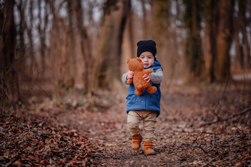 Toddler with Teddy Bear in Nature. Innocent toddler clutching a teddy bear, a comforting presence on his outdoor adventure