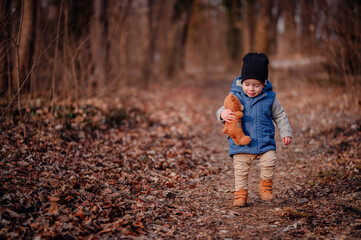 Toddler with Teddy Bear in Nature. Innocent toddler clutching a teddy bear, a comforting presence on his outdoor adventure