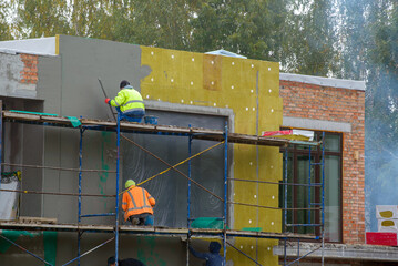 External wall insulation. Energy efficiency house wall renovation for energy saving. Exterior house wall heat insulation with mineral wool, building under construction.