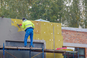 view of construction worker in doing insulation of wall at construction site