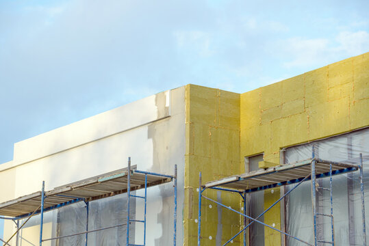 External wall insulation. Energy efficiency house wall renovation for energy saving. Exterior house wall heat insulation with mineral wool, building under construction.